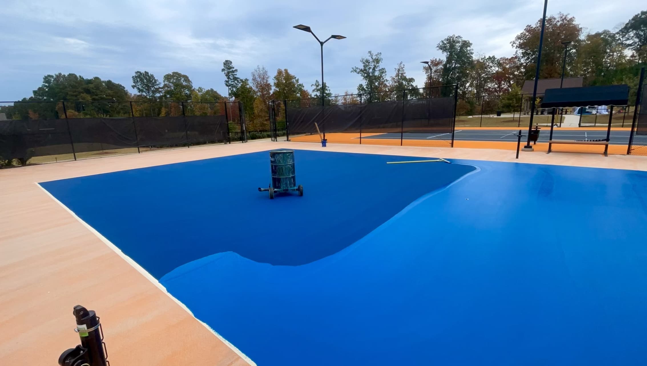 Tennis court surfacing application in progress